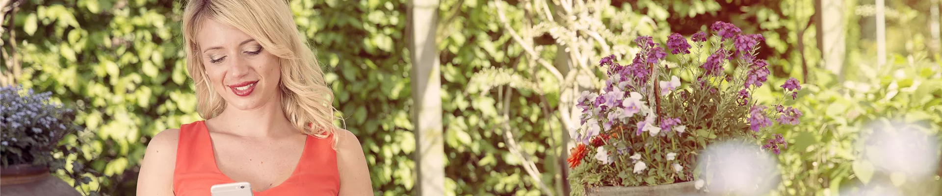 Frau im Garten mit Smartphone